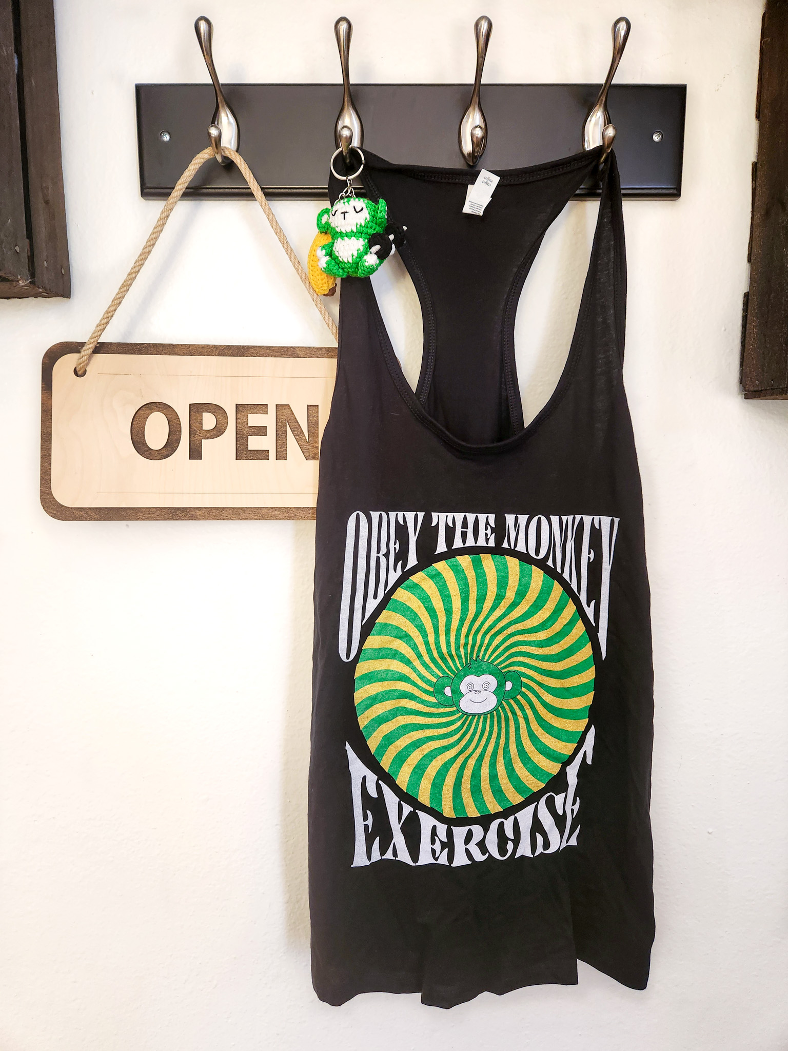 Fit Monkeys branded exercise tank top and monkey accessory displayed inside the Carlsbad studio.
